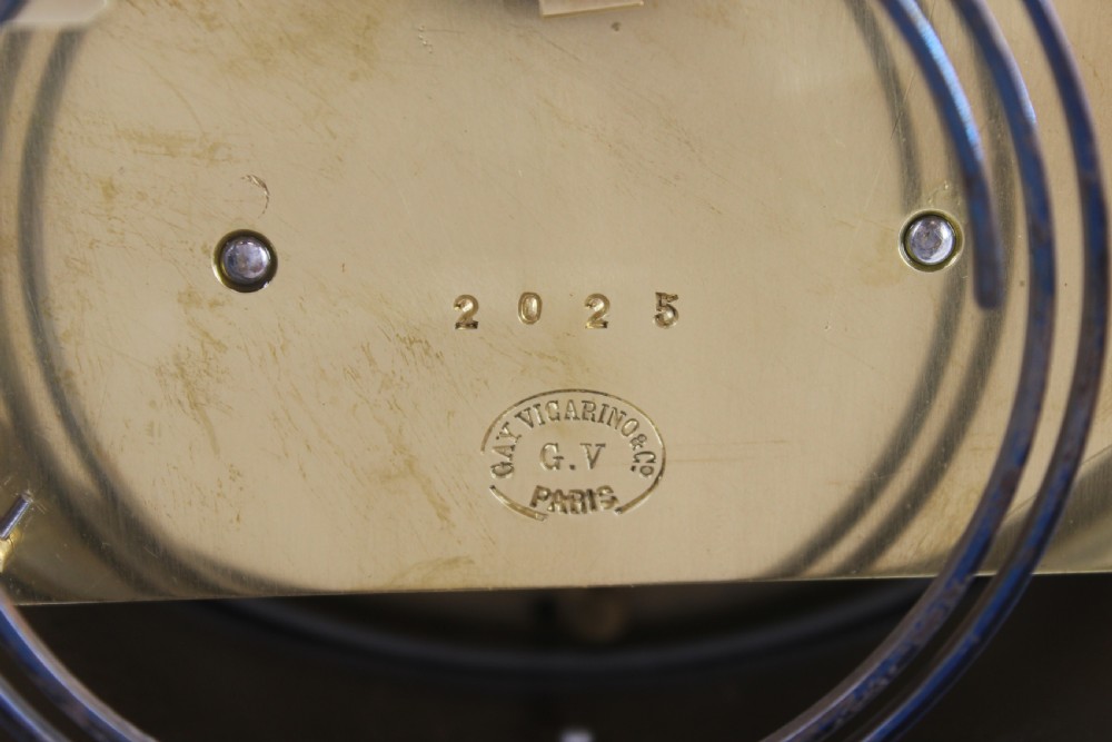 A chrome-plated nautical desk clock styled as a ship wheel mounted on a rectangular plinth with a cream dial and Roman numerals. View IX