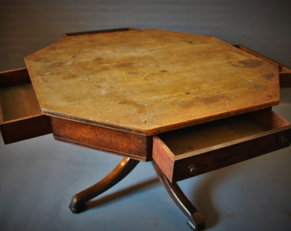 An antique Victorian octagonal oak drum table featuring frieze drawers with turned wooden knobs, supported by a central turned pedestal with four splayed legs. View II