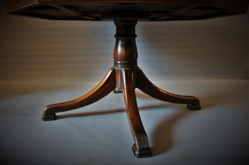 An antique Victorian octagonal oak drum table featuring frieze drawers with turned wooden knobs, supported by a central turned pedestal with four splayed legs. View III
