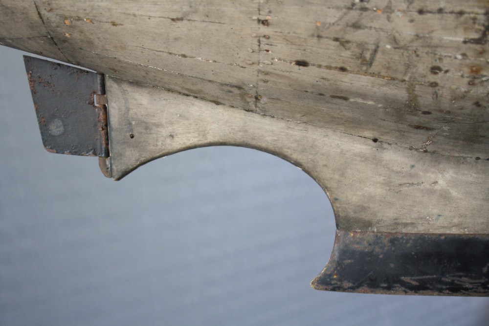 A large carved wooden pond yacht hull featuring exposed interior deck ribs and a weighted metal keel. View VI