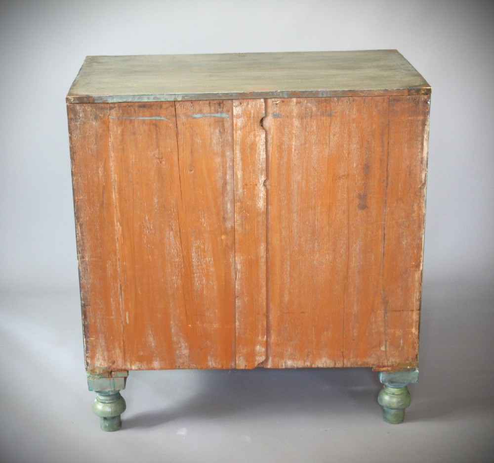 A Victorian green painted campaign chest of drawers with flush brass corner mountings, recessed brass handles, side carrying handles, and turned feet. View III