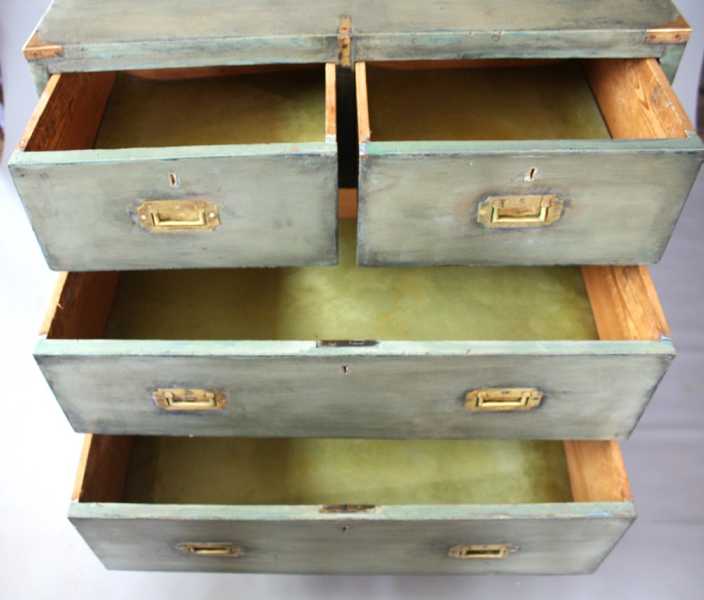 A Victorian green painted campaign chest of drawers with flush brass corner mountings, recessed brass handles, side carrying handles, and turned feet. View IV