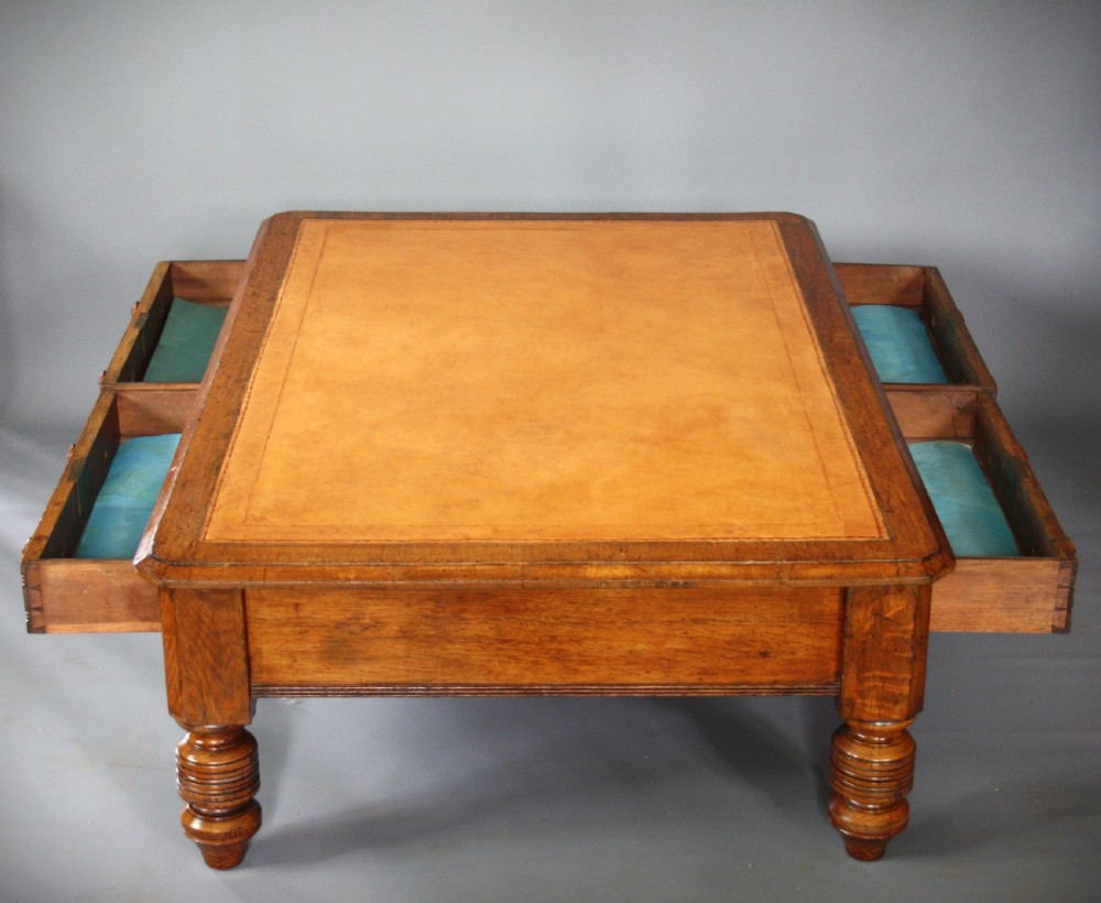 A low rectangular golden oak coffee table featuring a leather inset top, two front drawers with turned wooden knobs, and stout turned legs. View II