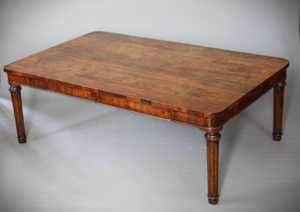 A low rectangular rosewood coffee table featuring rounded corners, a veneered apron, and fluted legs.