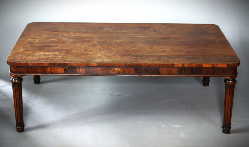 A low rectangular rosewood coffee table featuring rounded corners, a veneered apron, and fluted legs. View III