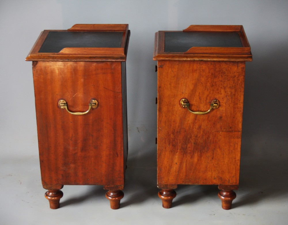 A pair of antique brown wooden military campaign bedside cabinets featuring three drawers each, brass side handles, and black leather tops. View III