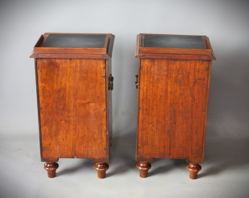 A pair of antique brown wooden military campaign bedside cabinets featuring three drawers each, brass side handles, and black leather tops. View IV