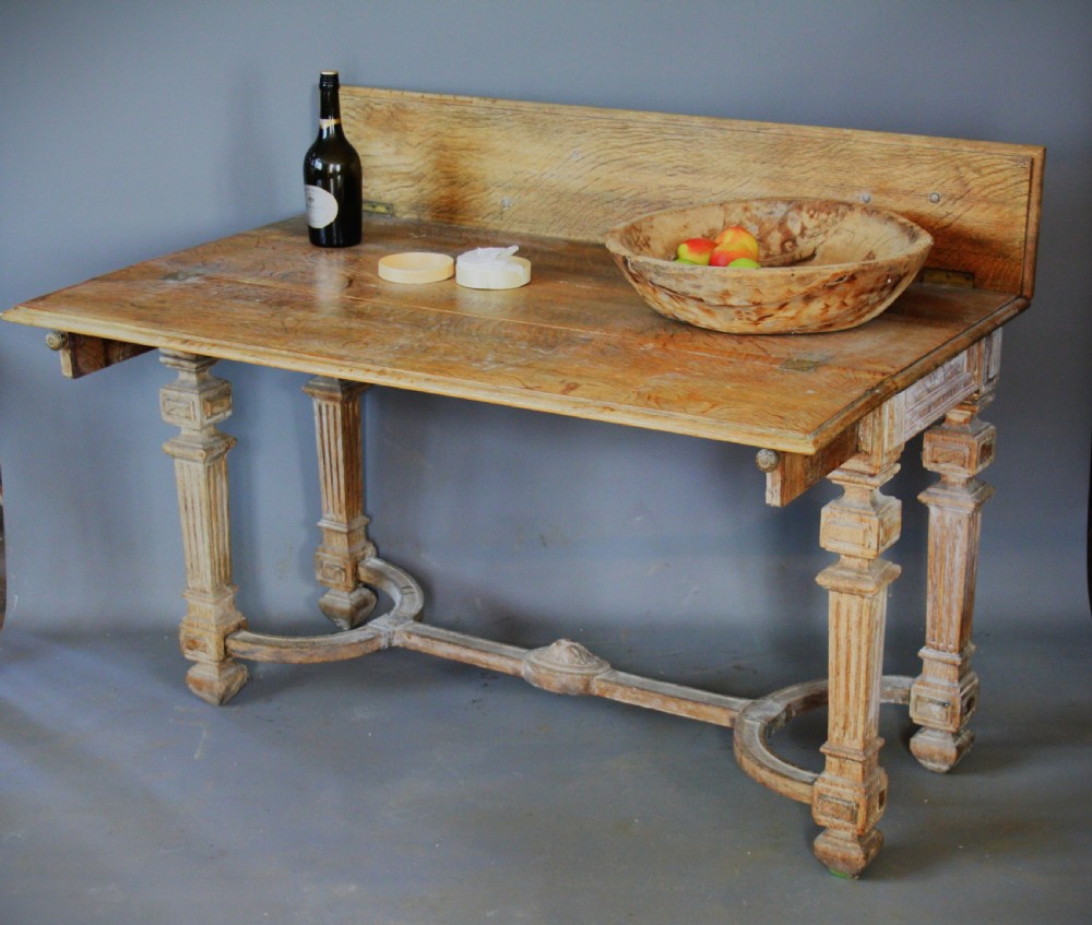 An antique light oak metamorphic console table featuring fluted square legs, a central carved rosette on the apron, a curved stretcher, and a hinged fold-over top. View II