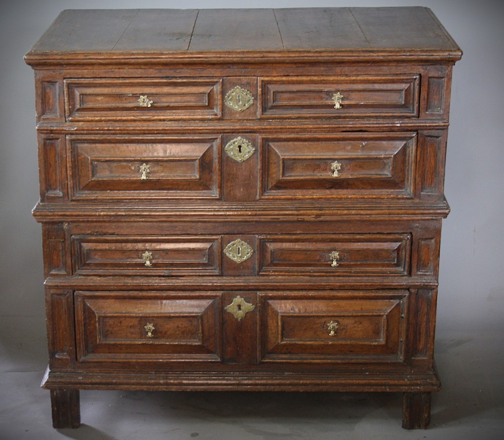 A late 17th-century dark oak chest of drawers featuring four drawers decorated with geometric mitred mouldings and brass keyhole escutcheons. View II
