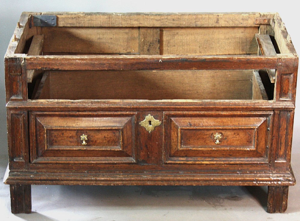 A late 17th-century dark oak chest of drawers featuring four drawers decorated with geometric mitred mouldings and brass keyhole escutcheons. View VII