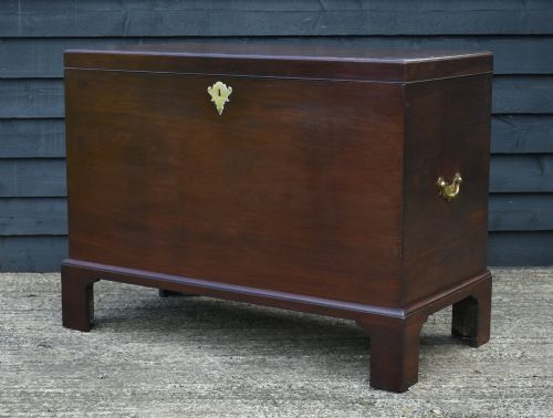 fig 1. A Georgian mahogany travelling chest featuring side brass carrying handles, an escutcheon lock, and raised bracket feet.