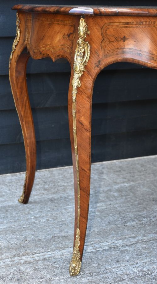 A nineteenth-century French kingwood writing desk featuring a serpentine top, marquetry inlay, slender cabriole legs, and ornate gilt bronze mounts. View VIII