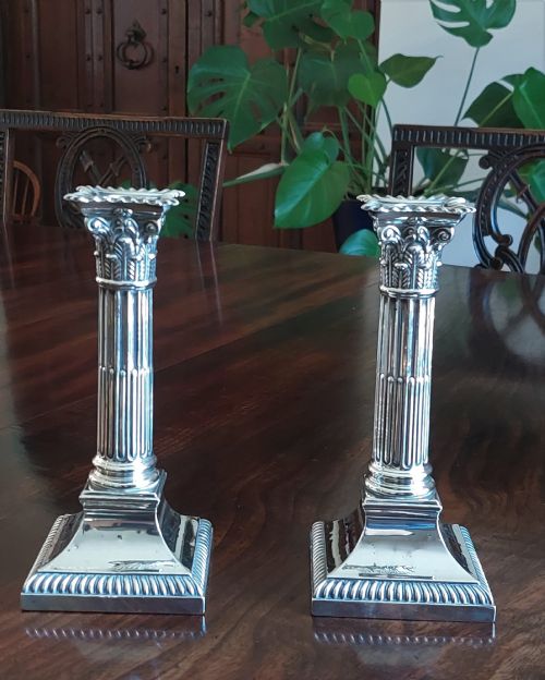 fig 1. A pair of sterling silver Corinthian column candlesticks featuring fluted shafts, acanthus leaf capitals, and gadrooned square bases.