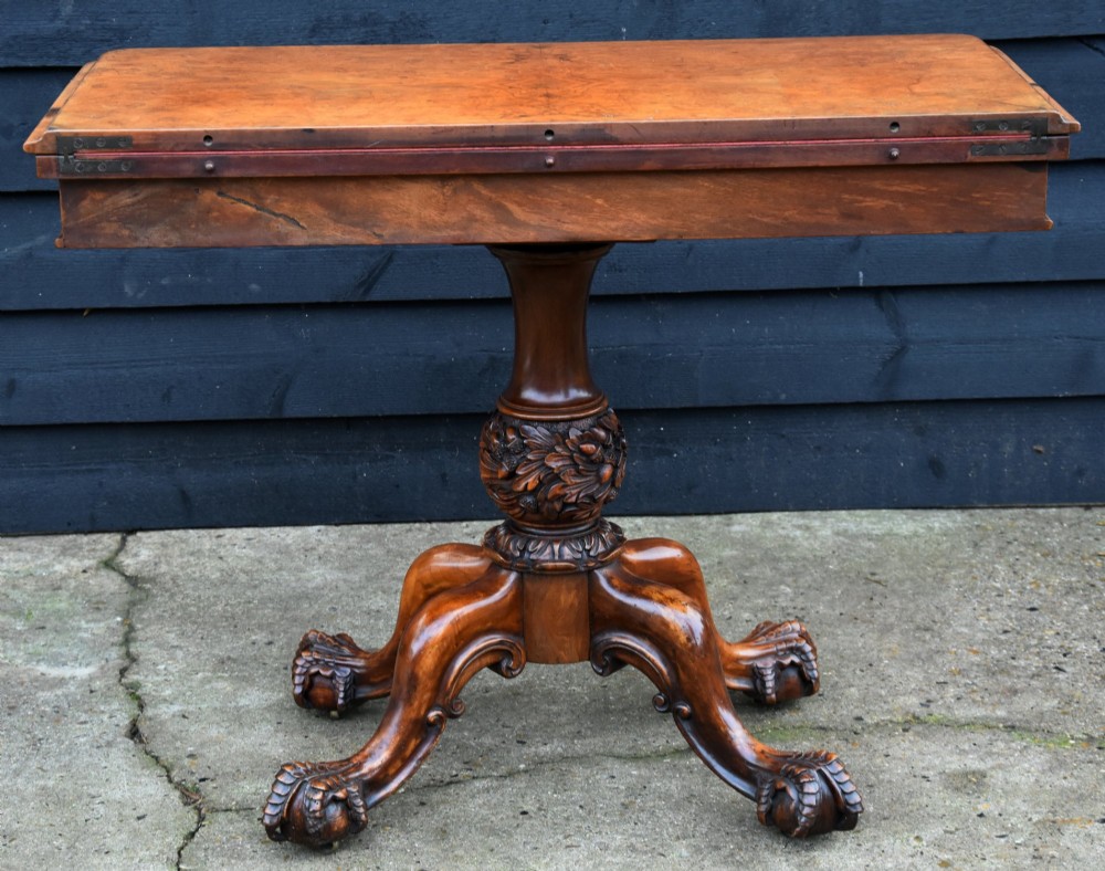 A Victorian burr walnut foldover card table featuring a rectangular swivel top, carved apron accent, turned pedestal stem with floral carving, and four cabriole legs ending in claw and ball feet. View IV