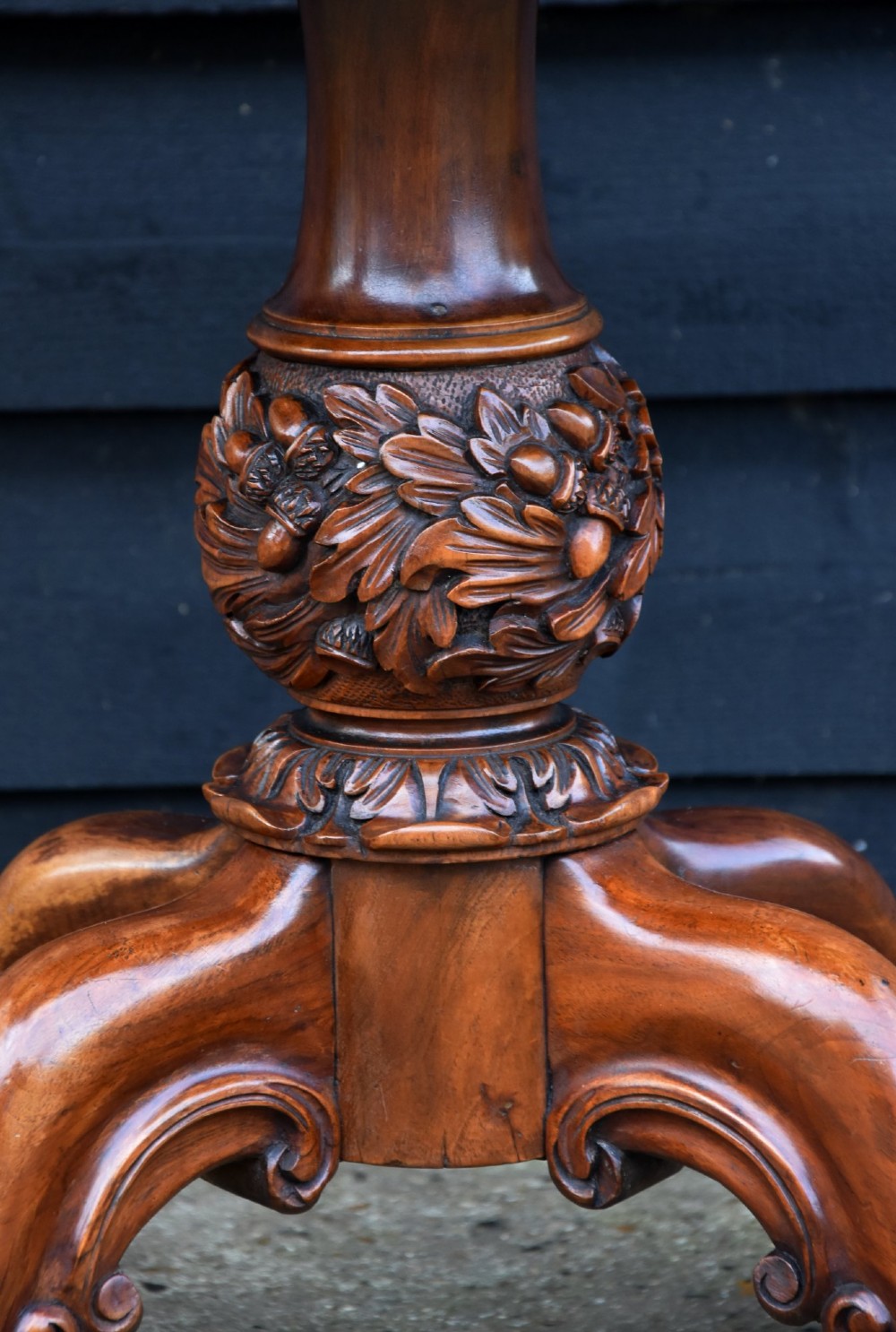 A Victorian burr walnut foldover card table featuring a rectangular swivel top, carved apron accent, turned pedestal stem with floral carving, and four cabriole legs ending in claw and ball feet. View X