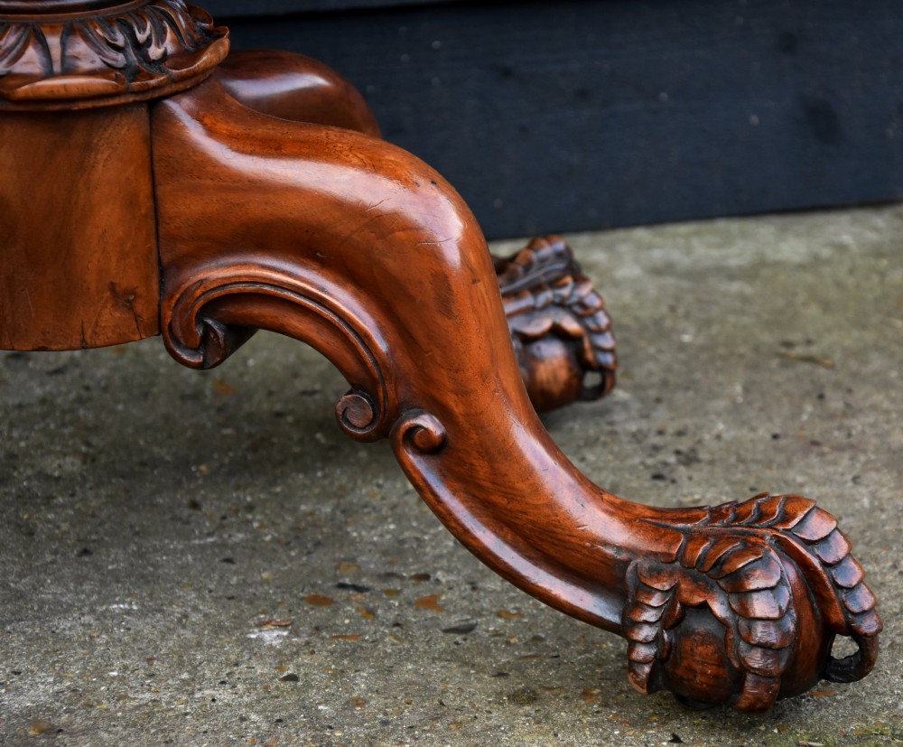 A Victorian burr walnut foldover card table featuring a rectangular swivel top, carved apron accent, turned pedestal stem with floral carving, and four cabriole legs ending in claw and ball feet. View XI