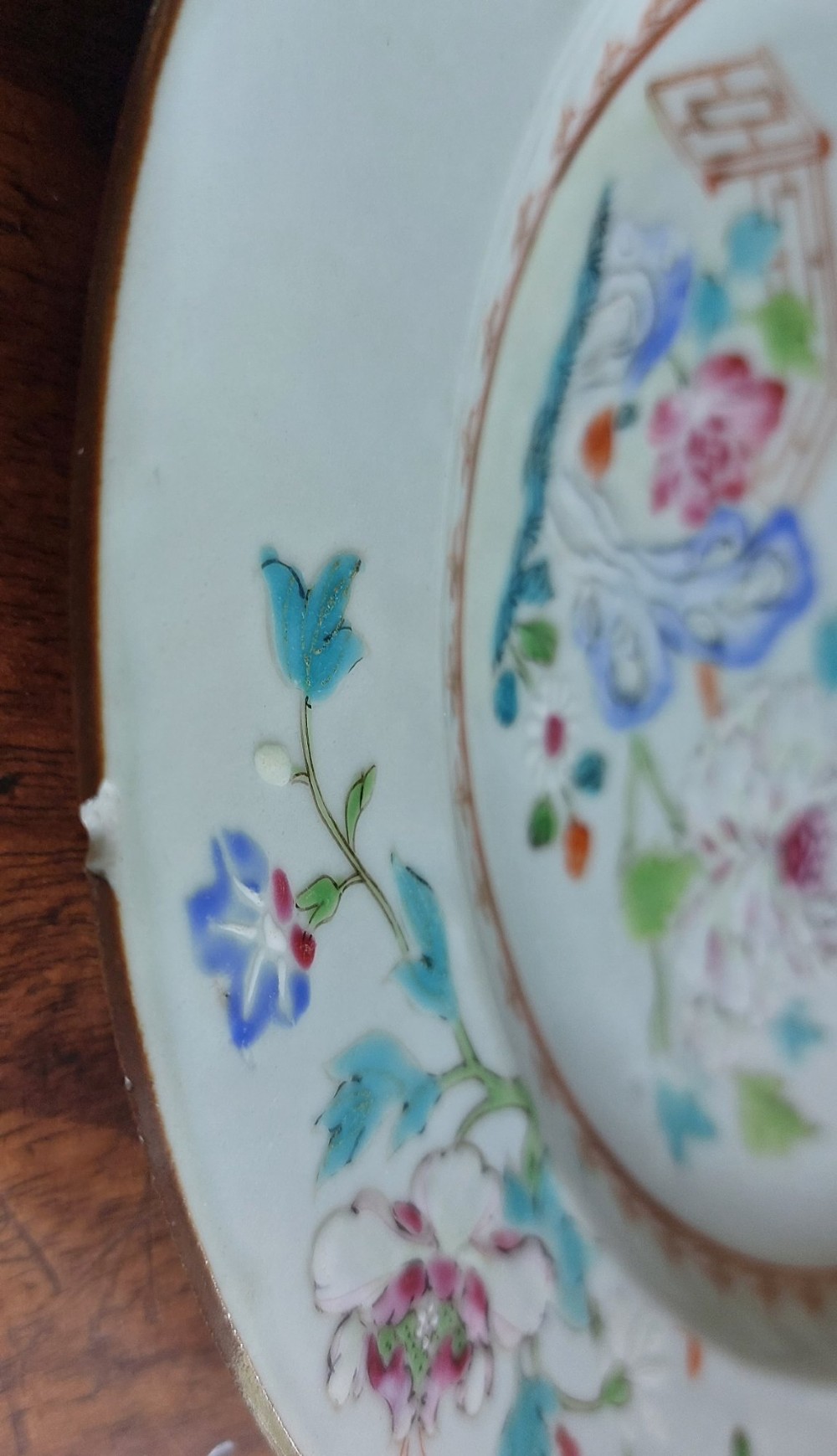 An 18th-century Chinese Qianlong period Famille Rose porcelain plate decorated with hand-painted polychrome floral motifs and rockwork. View II
