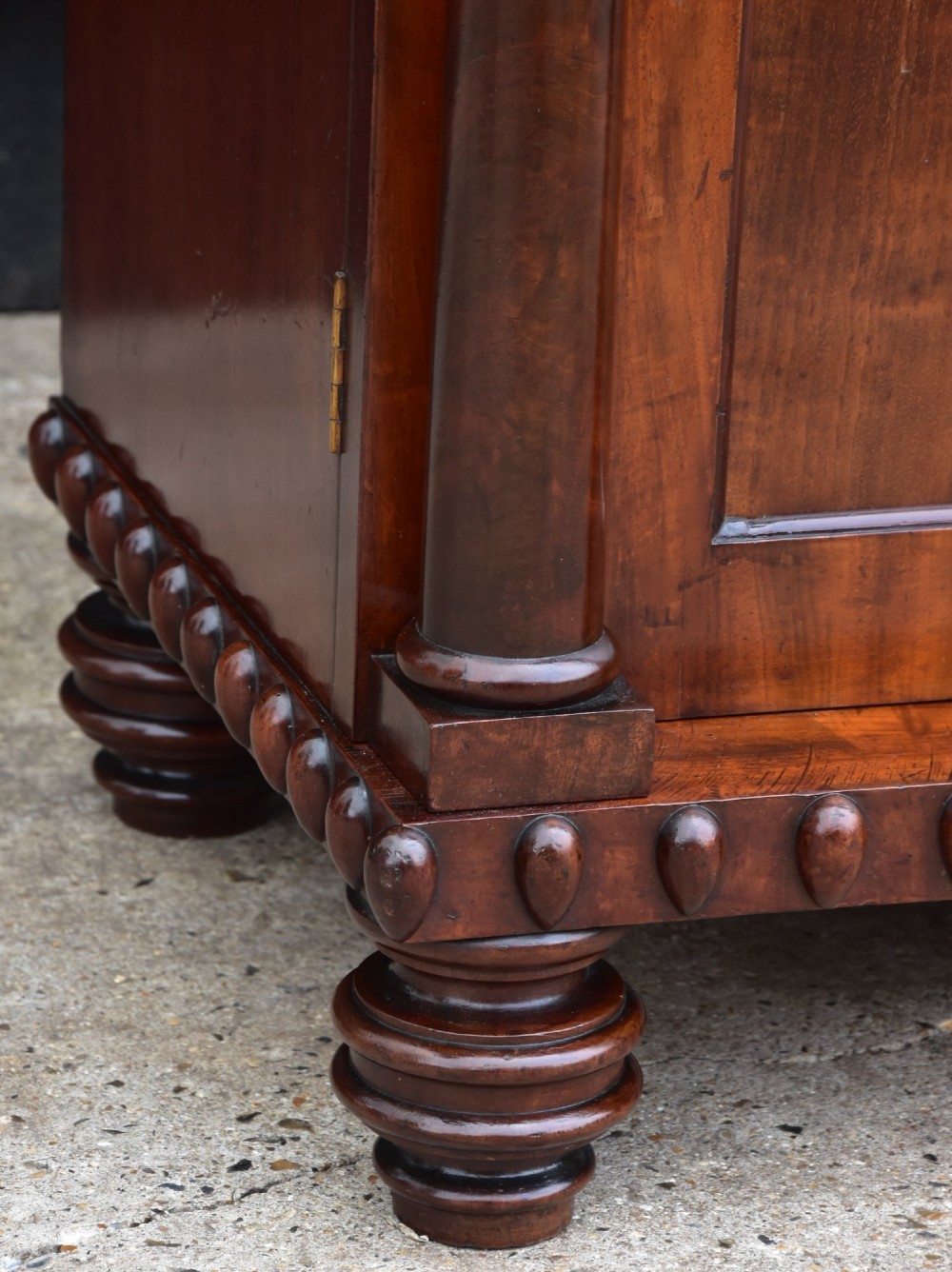 A Regency mahogany chiffonier side cabinet featuring a carved cresting gallery shelf, flame mahogany cupboard doors, and turned feet. View III