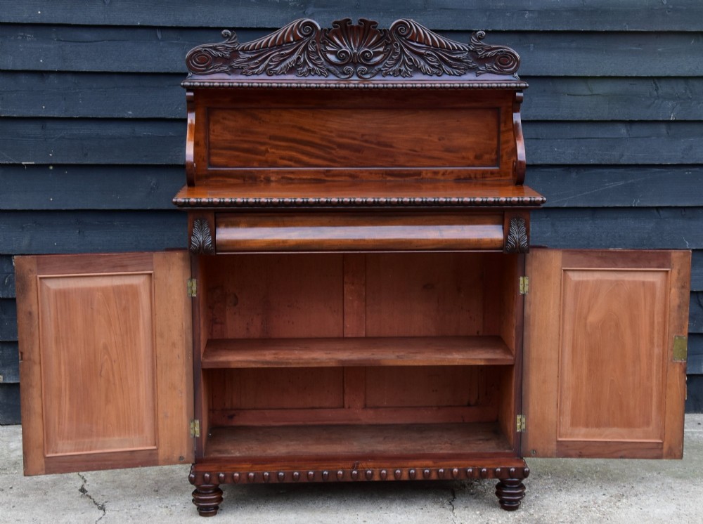A Regency mahogany chiffonier side cabinet featuring a carved cresting gallery shelf, flame mahogany cupboard doors, and turned feet. View VIII