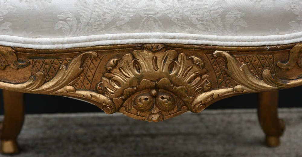Pair of late 19th-century French giltwood armchairs upholstered in cream damask with carved cresting and cabriole legs. View V