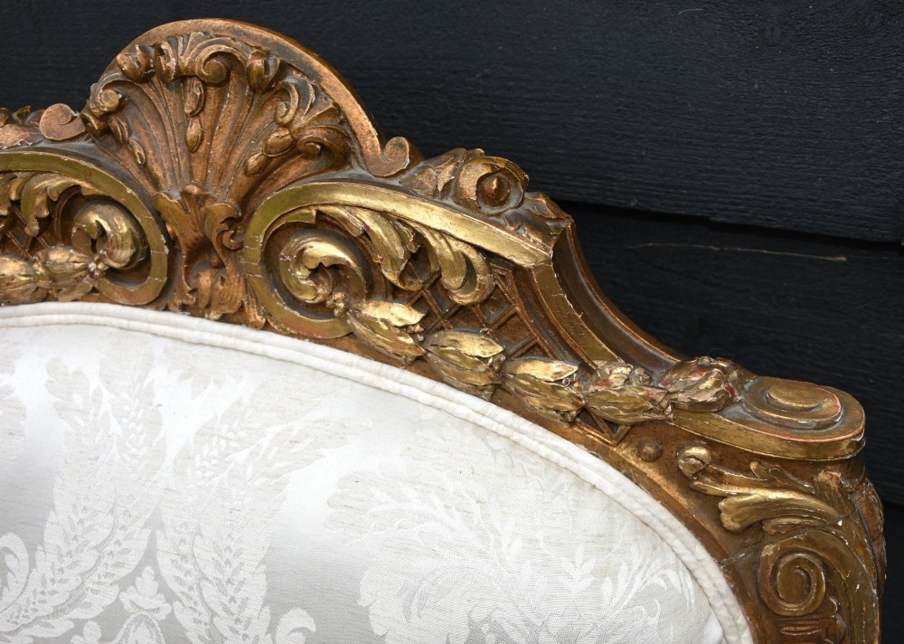Pair of late 19th-century French giltwood armchairs upholstered in cream damask with carved cresting and cabriole legs. View IX