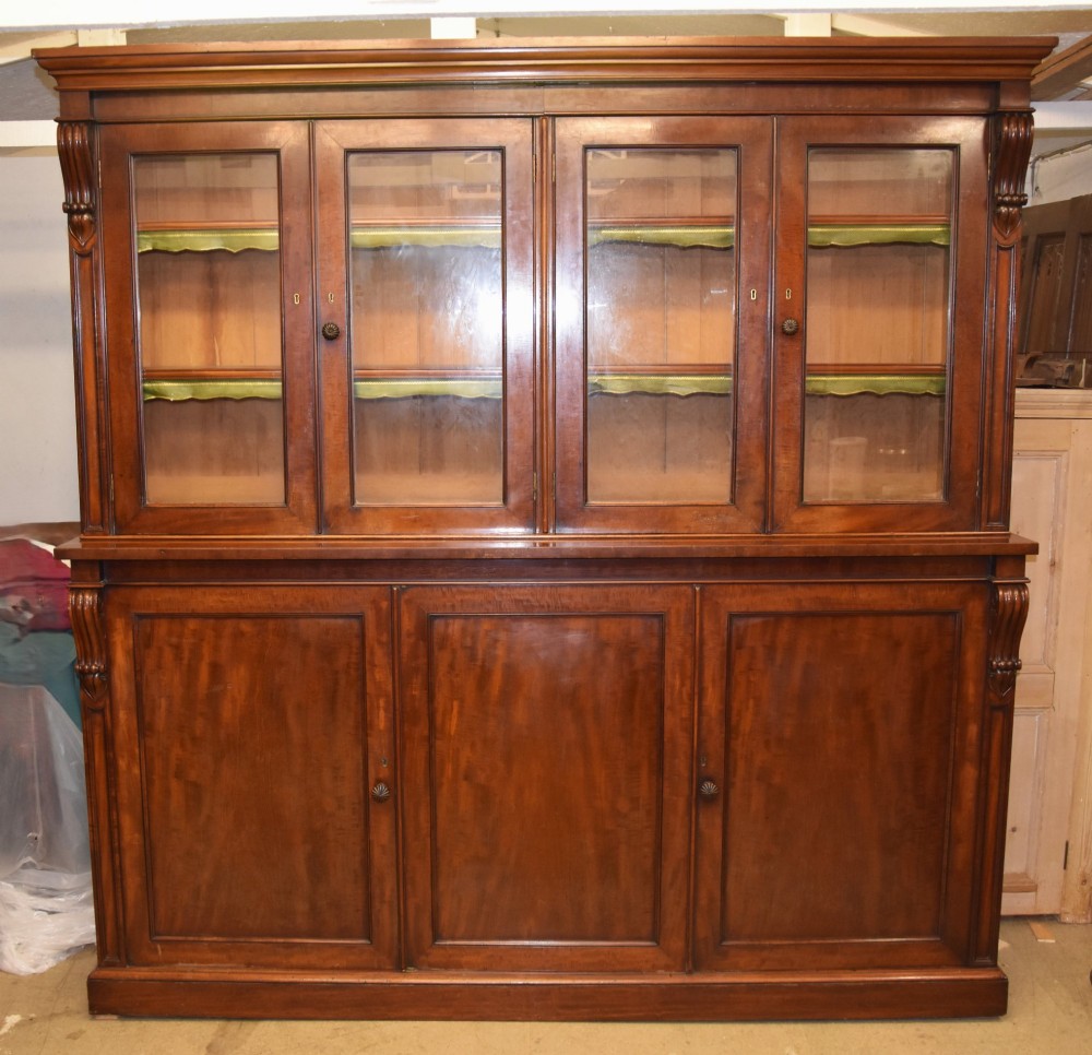 A large William IV mahogany triple bookcase cabinet featuring four upper glazed doors and three lower solid panelled doors. View II
