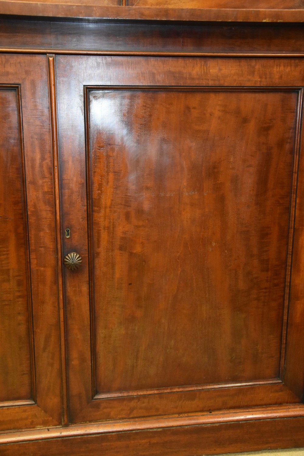 A large William IV mahogany triple bookcase cabinet featuring four upper glazed doors and three lower solid panelled doors. View VII