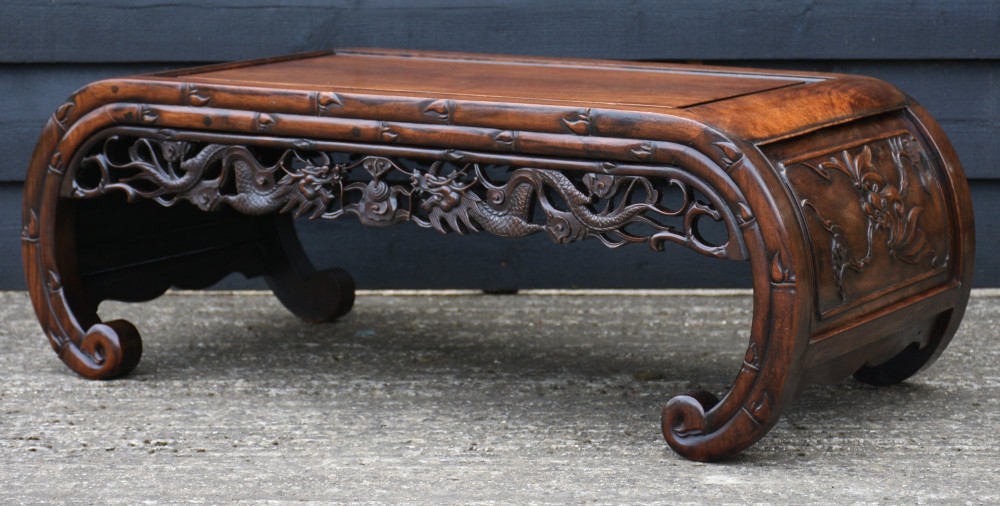 A low Chinese rosewood table with relief-carved dragon aprons, simulated bamboo moulding, and inward-curving scroll feet. View V