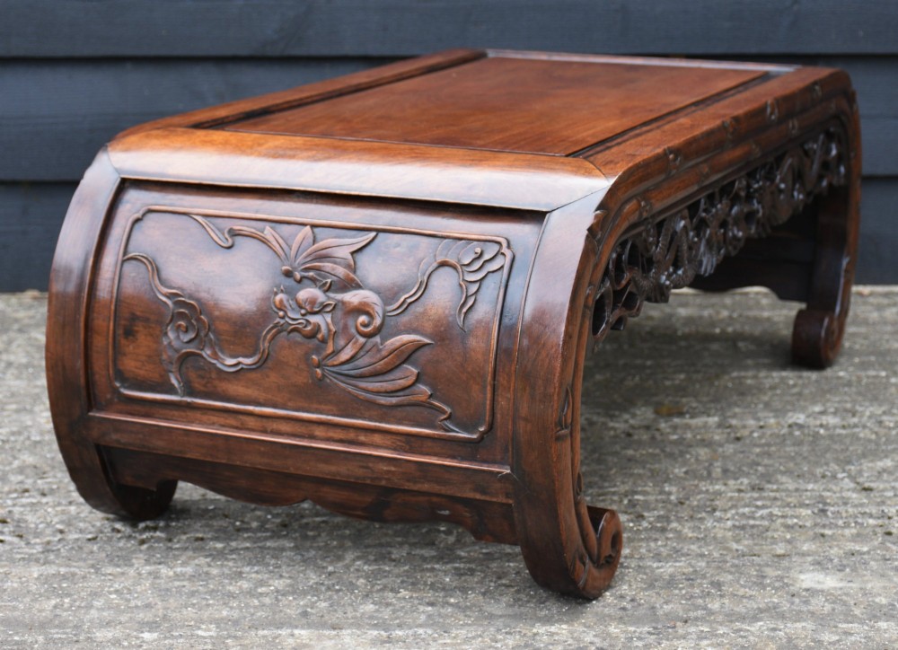 A low Chinese rosewood table with relief-carved dragon aprons, simulated bamboo moulding, and inward-curving scroll feet. View VII