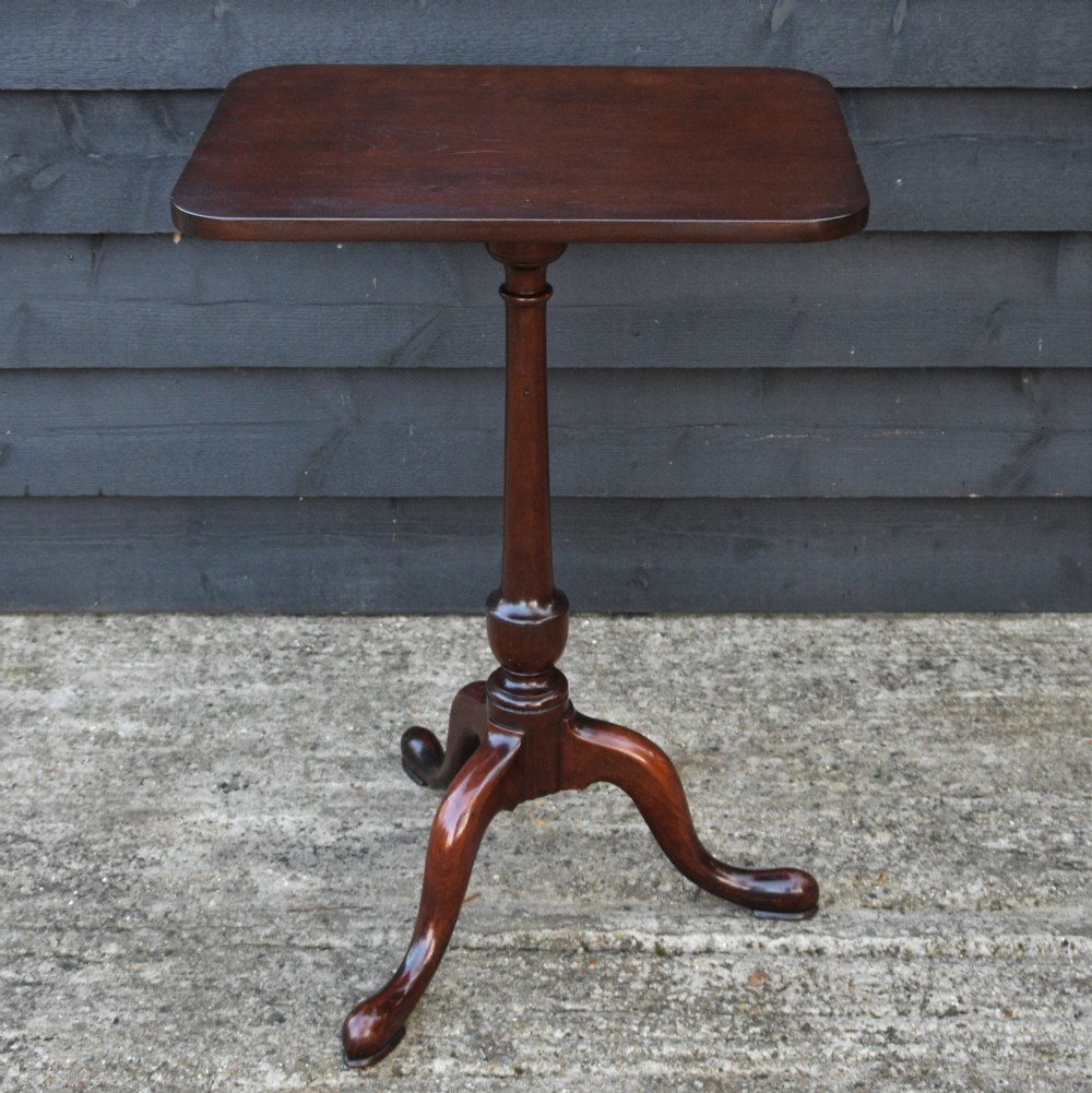 A 19th-century fruitwood tilt-top wine table with a rectangular rounded top, a turned column pedestal, and a tripod base.