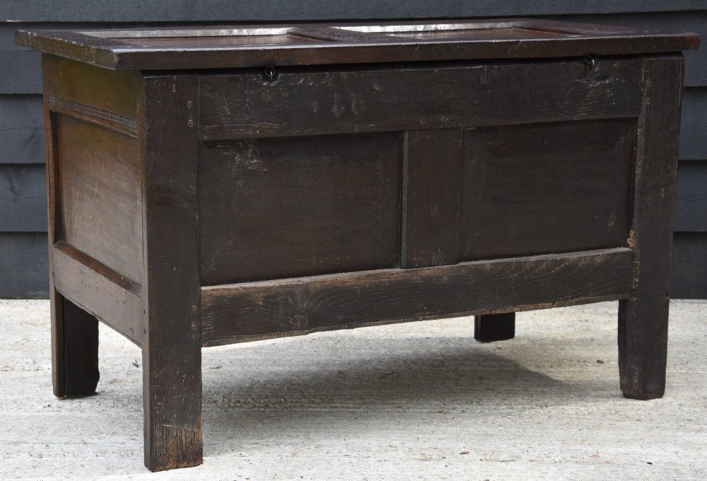 A small 17th-century dark oak coffer with a carved lunette frieze, twin front panels, peg joints, and a wrought iron lock plate. View VI