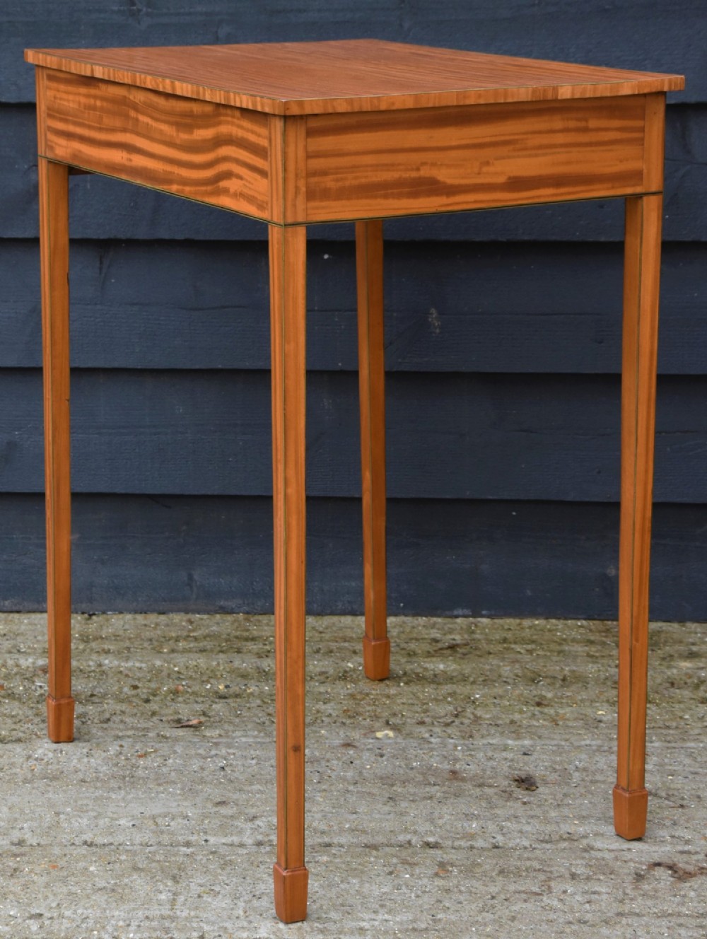 An antique Georgian satinwood lamp table featuring a single drawer with octagonal brass ring handles and slim square tapered legs. View VI