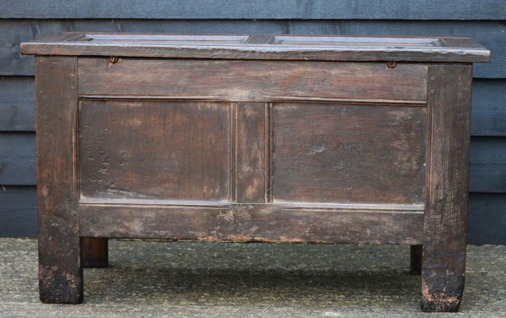 A seventeenth-century oak coffer featuring a twin-panelled front, moulded lid, stile legs, and a central iron keyhole escutcheon. View VI