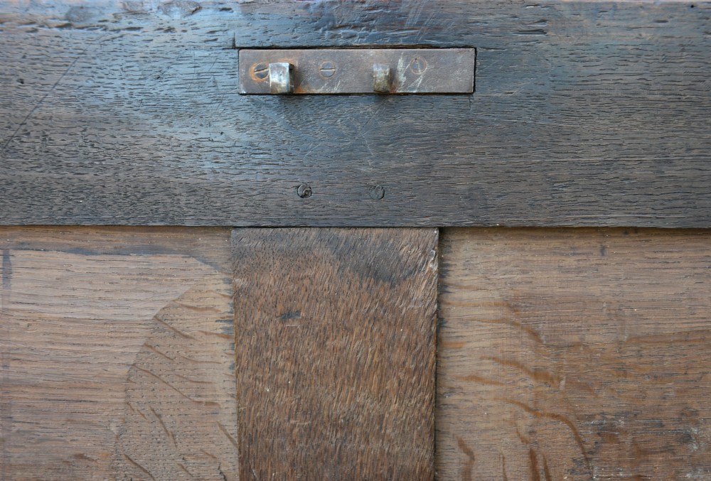 A seventeenth-century oak coffer featuring a twin-panelled front, moulded lid, stile legs, and a central iron keyhole escutcheon. View XI