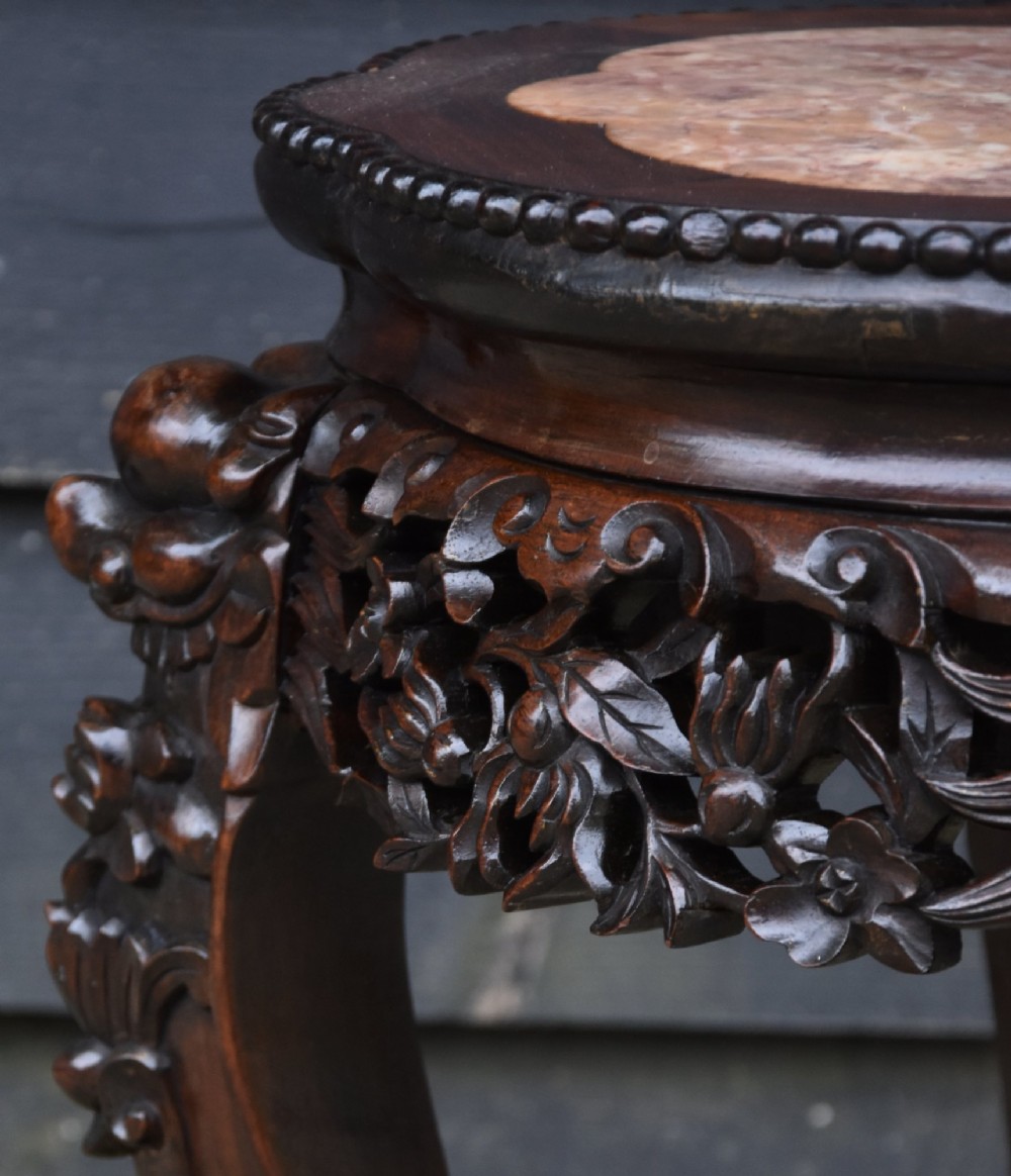A circular 19th-century Chinese dark rosewood low table featuring an inset marble top, detailed floral openwork aprons, and cabriole legs ending in carved feet. View IV