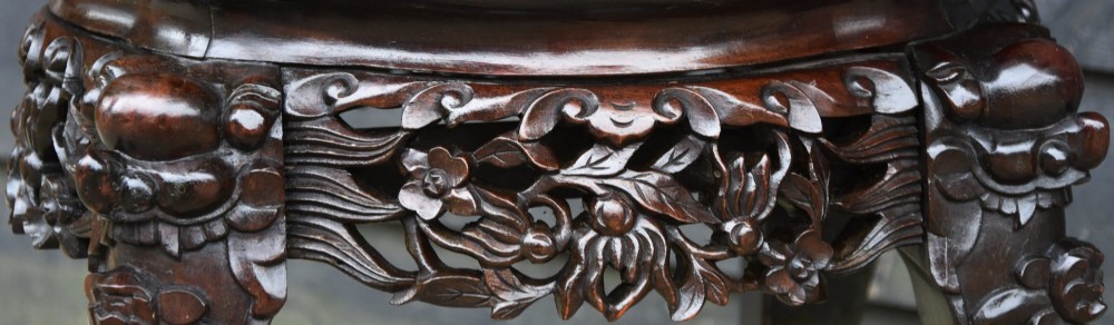 A circular 19th-century Chinese dark rosewood low table featuring an inset marble top, detailed floral openwork aprons, and cabriole legs ending in carved feet. View VI
