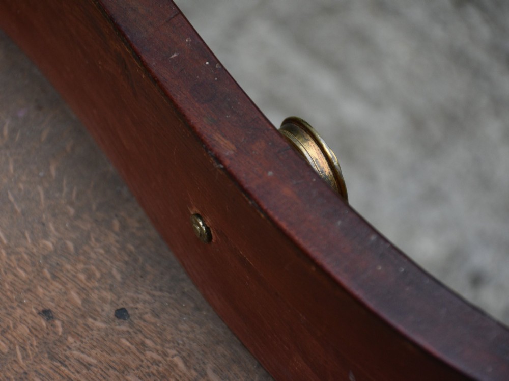 A late 18th-century Georgian mahogany serpentine chest of drawers featuring four graduated drawers with brass handles and bracket feet. View VII