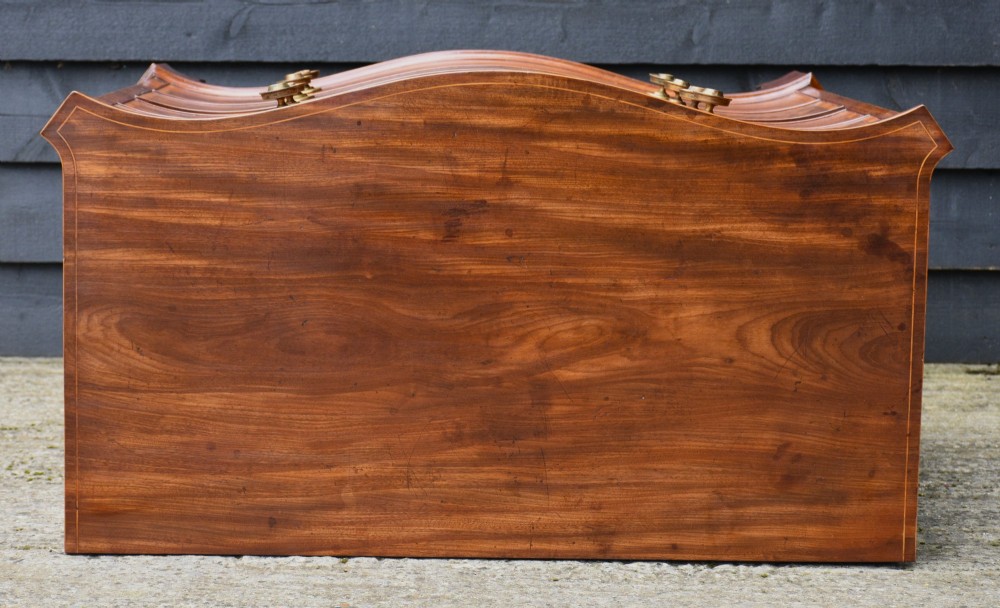 A late 18th-century Georgian mahogany serpentine chest of drawers featuring four graduated drawers with brass handles and bracket feet. View XII