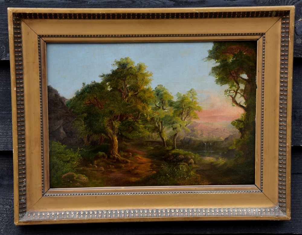 A 19th-century oil painting on board depicting a leafy woodland landscape with a path and distant hills, housed within a moulded gilt frame.