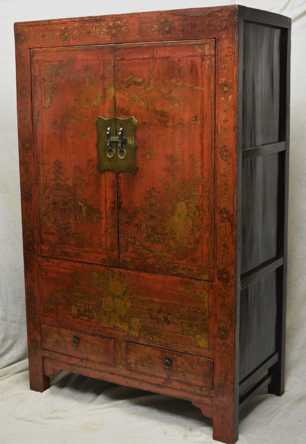 An early nineteenth-century Chinese red lacquered cabinet decorated with gilded landscape scenes, a brass faceplate, and two lower drawers. View III