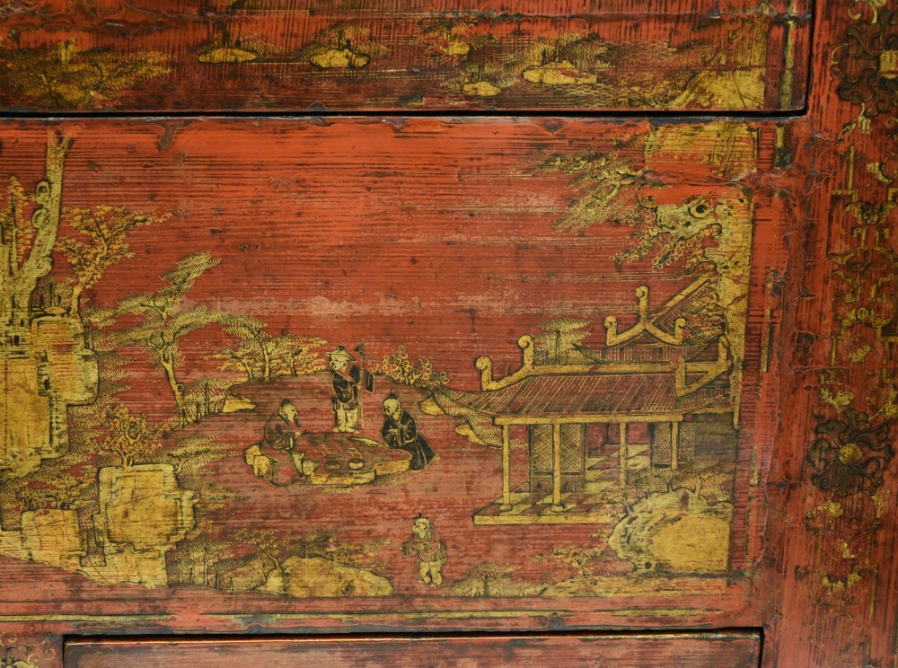An early nineteenth-century Chinese red lacquered cabinet decorated with gilded landscape scenes, a brass faceplate, and two lower drawers. View IV