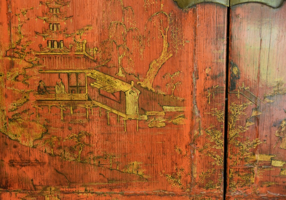 An early nineteenth-century Chinese red lacquered cabinet decorated with gilded landscape scenes, a brass faceplate, and two lower drawers. View V