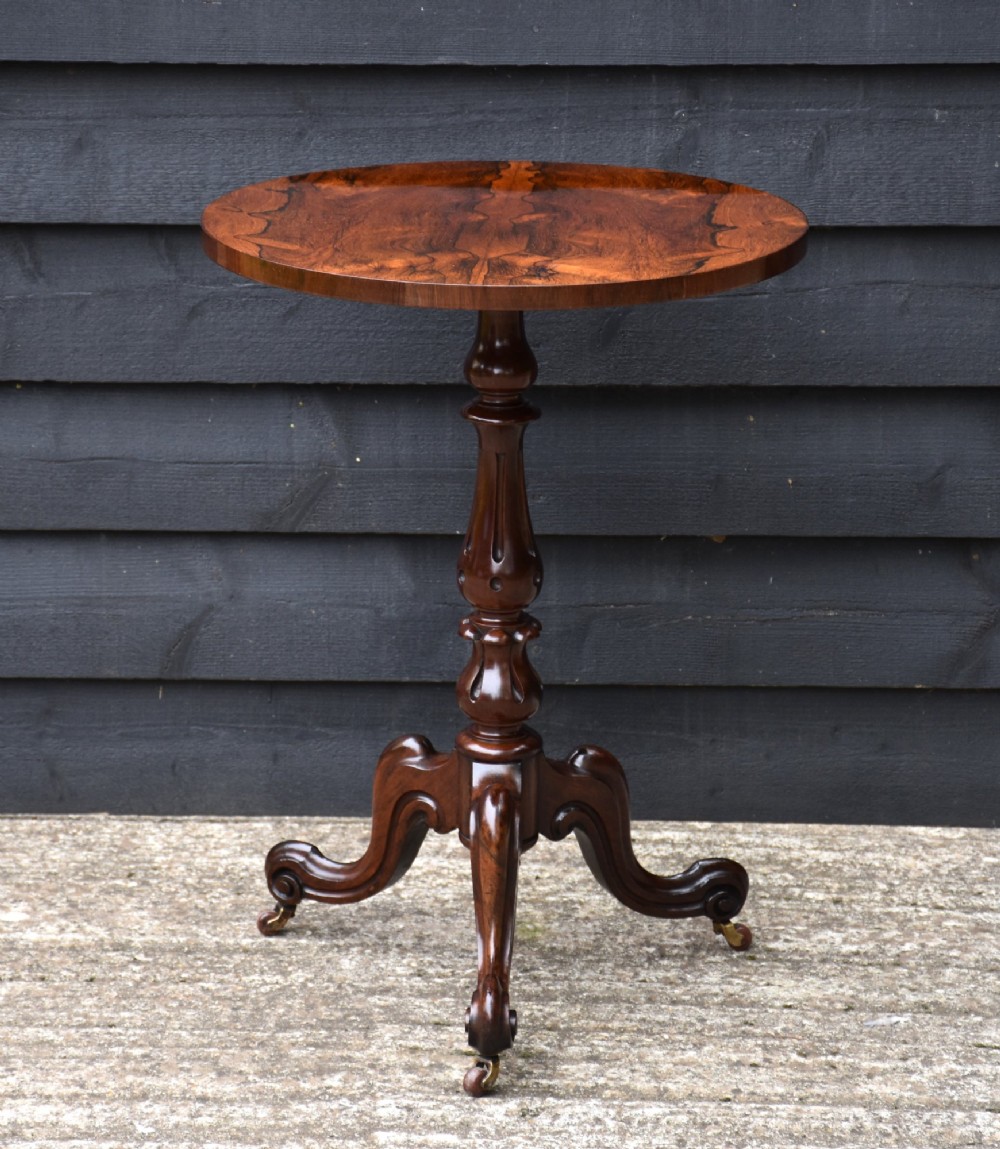 A circular 19th-century rosewood lamp table featuring a bookmatched wood grain top resting on a carved pedestal stem with tripod legs. View II