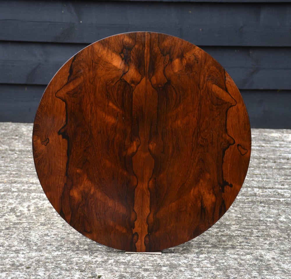 A circular 19th-century rosewood lamp table featuring a bookmatched wood grain top resting on a carved pedestal stem with tripod legs. View V