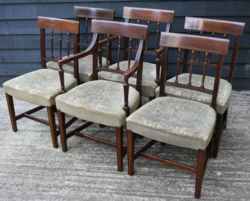 Set of six mahogany Georgian style dining chairs featuring spindle backrests, turned legs, and floral tapestry upholstery.