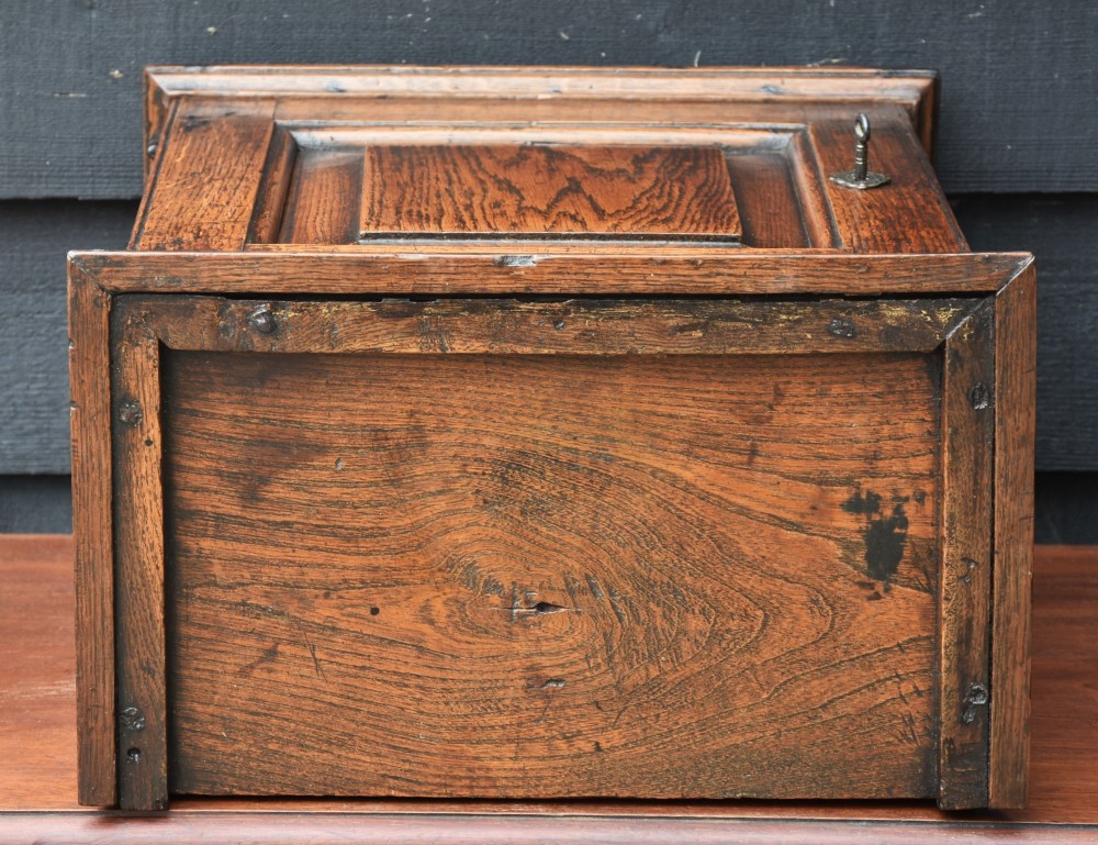 An early 18th-century oak spice cupboard featuring a single fielded panel door, brass escutcheon, and moulded top and base trim. View IX