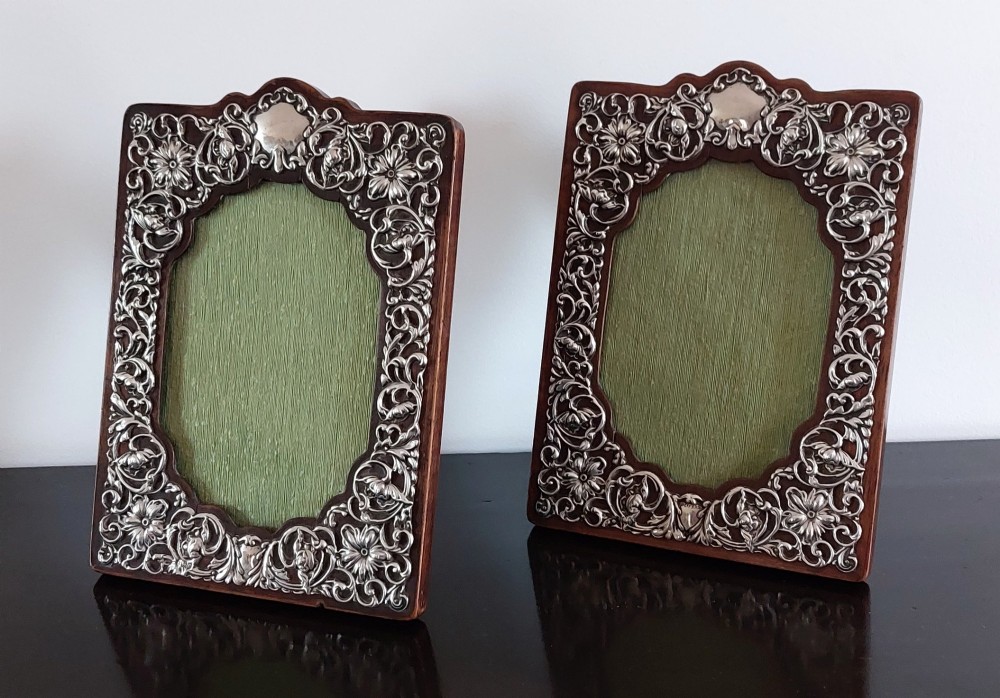 A pair of rectangular Edwardian photo frames featuring pierced scrollwork silver fronts mounted onto dark hardwood backings. View II