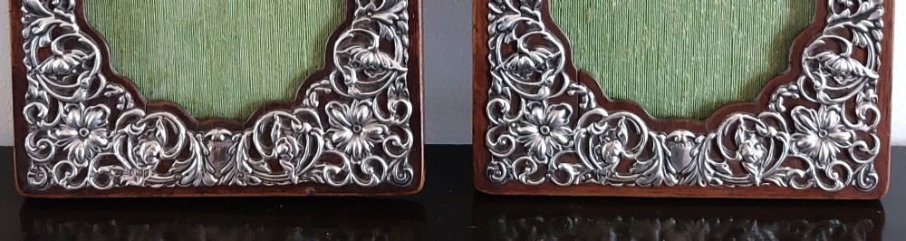 A pair of rectangular Edwardian photo frames featuring pierced scrollwork silver fronts mounted onto dark hardwood backings. View IV