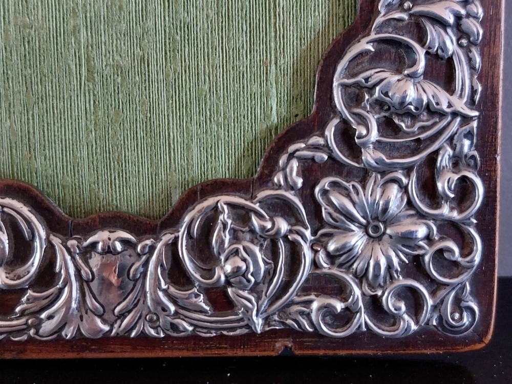 A pair of rectangular Edwardian photo frames featuring pierced scrollwork silver fronts mounted onto dark hardwood backings. View V