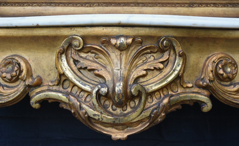 A French giltwood pier mirror featuring a carved rocaille cresting, mounted above a matching marble-topped console table with cabriole legs. View IV